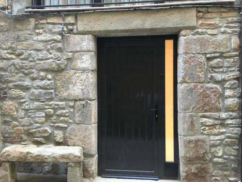 uma porta preta no lado de um edifício de pedra em Casa Tato Figuerola d'Orcau em Figuerola de Orcau