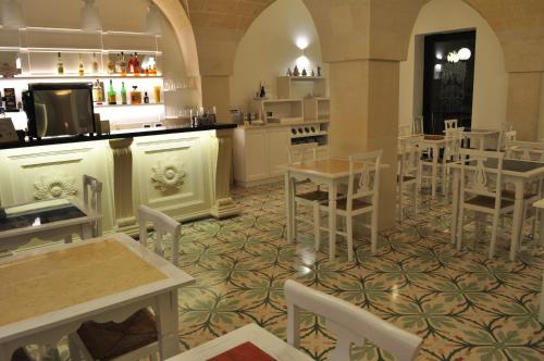 a restaurant with white chairs and tables and a bar at Villa Rosa Antico Dimora Storica in Otranto