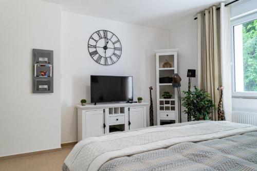 a bedroom with a bed and a clock on the wall at Beautiful Apartment in town centre (TLA/TDY/TLF) in Landstuhl