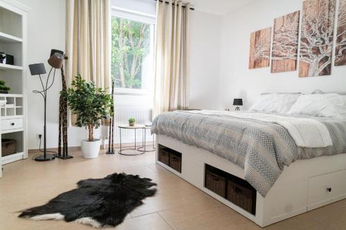 a bedroom with a bed with a black dog laying on the floor at Beautiful Apartment in town centre (TLA/TDY/TLF) in Landstuhl