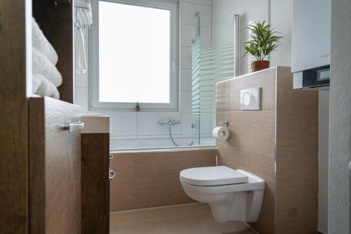 La salle de bains est pourvue de toilettes, d'une baignoire et d'une fenêtre. dans l'établissement Beautiful Apartment in town centre (TLA/TDY/TLF), à Landstuhl