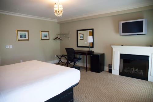 a bedroom with a bed and a desk and a fireplace at Niagara Crossing Hotel and Spa in Lewiston