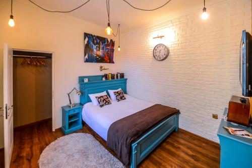 Un dormitorio con una cama azul y una pared de ladrillo en ATRIUM 24 Suite, en Sighişoara