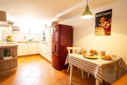 eine Küche mit einem Tisch und einem Kühlschrank in der Unterkunft Ferienwohnung Casa Sophia in Seeheim-Jugenheim
