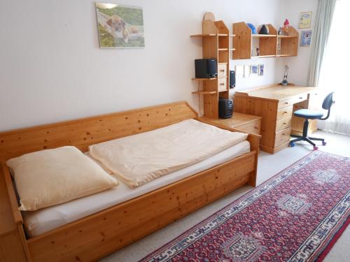 a bedroom with a wooden bed and a desk at Stadtwohnung Franz bis 6 Personen Hallein bei Salzburg in Hallein