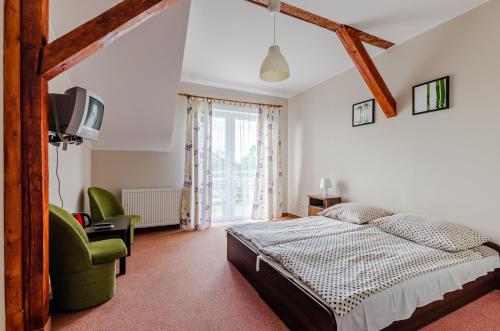 une chambre avec un lit, une chaise et une télévision dans l'établissement Willa Oceania, à Władysławowo