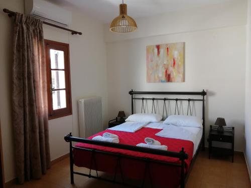 a bedroom with a bed with a red comforter at Sofirene Sea View in Batsi