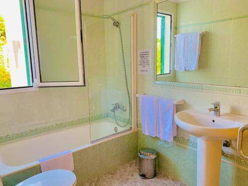 a bathroom with a sink and a shower at Villa CAROLINA in Cala en Forcat