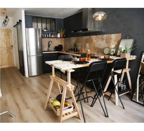 a kitchen with a table and chairs and a refrigerator at T2 au coeur de Bayonne in Bayonne