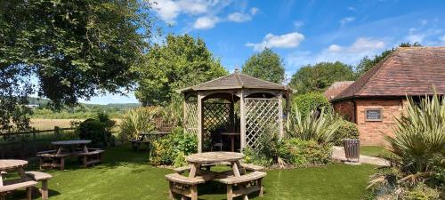 a gazebo and picnic tables in a garden at Meadow Farm Redditch by Marstons Inns in Redditch