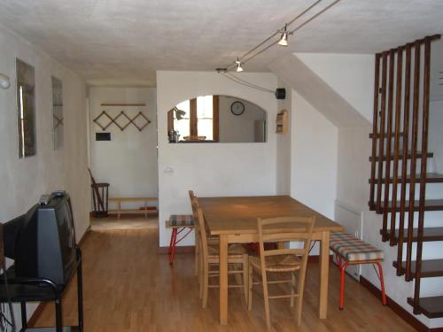 - une salle à manger avec une table et des chaises en bois dans l'établissement The House on the Bridge- La Casa sul Ponte, à Menaggio