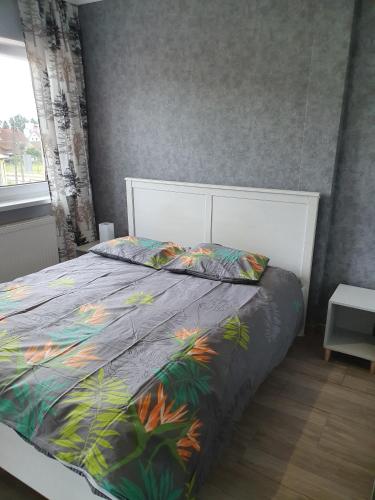 1 dormitorio con 1 cama con un edredón colorido en Noclegi Róża Wiatrów en Górowo Iławeckie