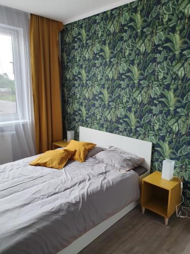 a bedroom with a bed with a green wall at Noclegi Róża Wiatrów in Górowo Iławeckie