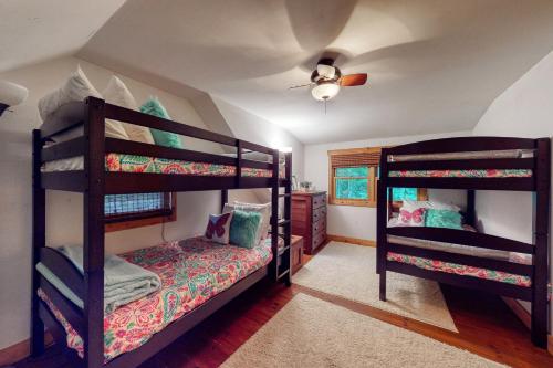 a bedroom with two bunk beds and a ceiling fan at Artist Brook Escape in North Conway