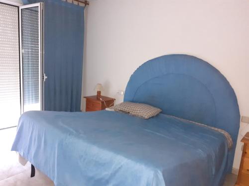 ein blaues Bett mit blauem Kopfteil in einem Schlafzimmer in der Unterkunft Casa URIN in Almenar
