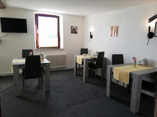 a dining room with tables and chairs and a window at Pension Riverside in Leverkusen Hitdorf am Rhein - Zentral an der A1 und 59 in Leverkusen