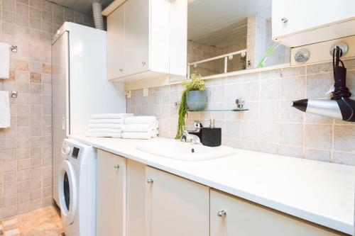 a bathroom with a sink and a washing machine at Tallinn City Apartments Old Town 3 bedroom in Tallinn