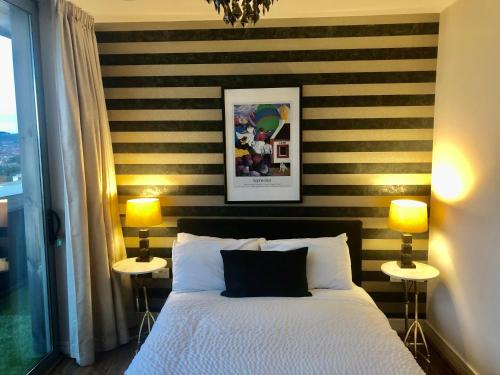 a bedroom with a black and white striped wall at CK Serviced Apartments Belfast in Belfast