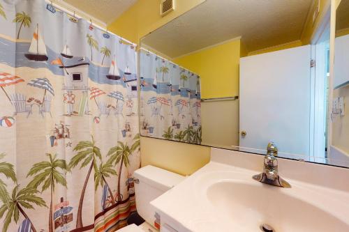 a bathroom with a sink and a toilet and a mirror at Beachfront Blessing in Myrtle Beach