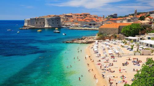 a group of people on a beach near the water at Apartment Marinero with FREE parking in Dubrovnik