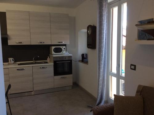 a kitchen with a sink and a microwave at Casa Ninou in Domaso