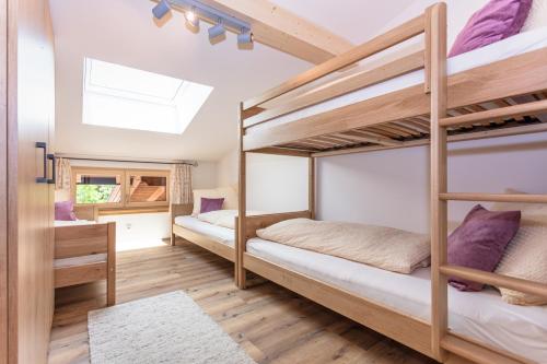 2 Etagenbetten in einem Zimmer mit Dachfenster in der Unterkunft Familienbauernhof Bairau Reifhorn in Lofer