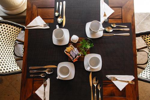 Doña Francisca Hotel Boutique في تالبا دي أليندي: طاولة عليها أطباق وأدوات مائدة