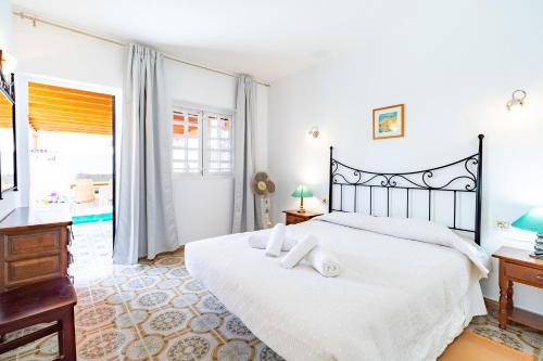 een slaapkamer met een groot wit bed en een bureau bij Casa El Sid in Puerto del Carmen