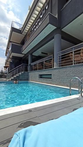 a large swimming pool in front of a building at Peloton Inn in Paralia Katerinis