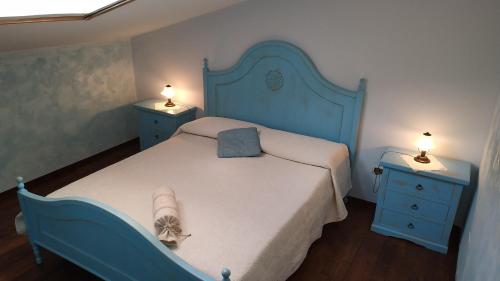 1 dormitorio con 1 cama azul y 2 mesitas de noche en Idillio Mediterraneo, en Magomadas