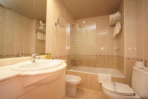 a bathroom with a sink and a toilet and a tub at Hotel & SPA Niunit in Ordino