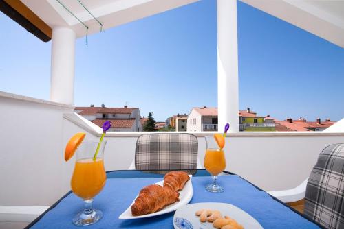una mesa con dos vasos de zumo de naranja y cruasanes en Apartment Blu, en Pula