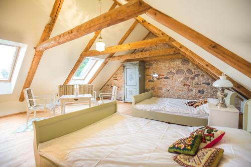 a room with two beds and a dining area in a attic at Pajusi Mõisa Külalistemaja in Põltsamaa