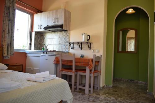 a kitchen with green walls and a table and chairs at Stamoulis Apartments in Agia Effimia