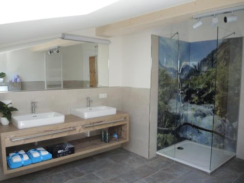 uma casa de banho com 2 lavatórios e um chuveiro em Familienbauernhof Bairau Reifhorn em Lofer