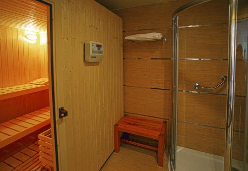 a walk in shower with a bench in a bathroom at Lagas Aegean Village in Kardamaina
