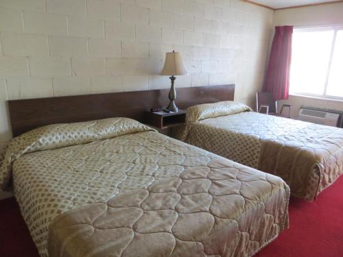 a hotel room with two beds and a window at Alamo Inn in Alamo