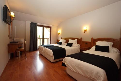Habitación de hotel con 2 camas y ventana en Hotel & SPA Niunit en Ordino