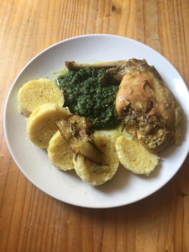 a plate of food with meat and greens on a table at Penzion U Lucerny s malou farmičkou in Kytlice