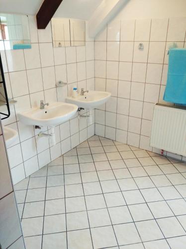 two sinks in a bathroom with white tiles at Penzion U Lucerny s malou farmičkou in Kytlice