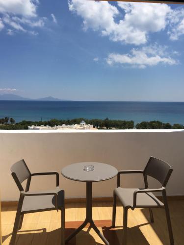 a table and two chairs on a balcony with the ocean at Lagas Aegean Village in Kardamaina