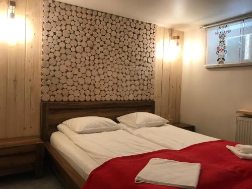 ヴィスワにあるVilla Karola Stryiのベッドルーム1室(白いシーツと赤い毛布を使用した大型ベッド1台付)
