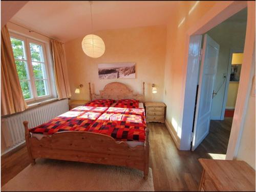 una camera da letto con un grande letto con una coperta rossa di Stadtvilla Marie Varel Dangast 4 Personen mit Sauna a Varel
