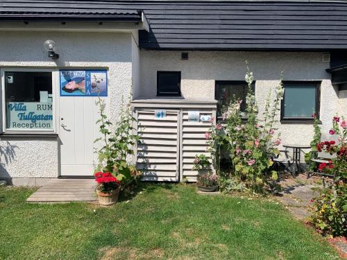 a house with a white door and some flowers at Villa Tullgatan Borgholm in Borgholm