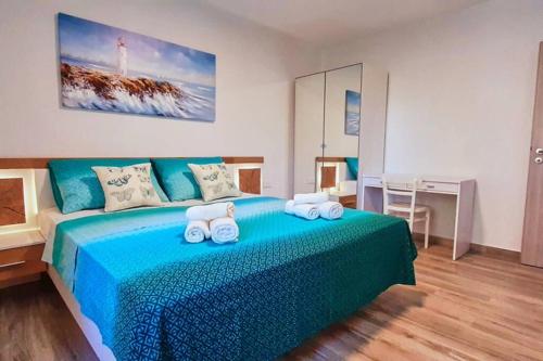 una camera da letto con un letto blu e asciugamani di Family Vacation House Zive a Zara (Zadar)