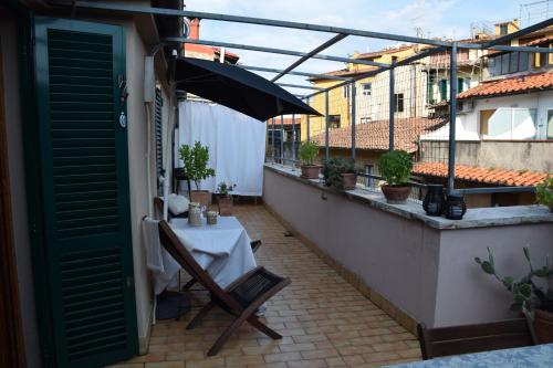 a table on a balcony with an umbrella at Terrazza in borgo San Jacopo in Florence