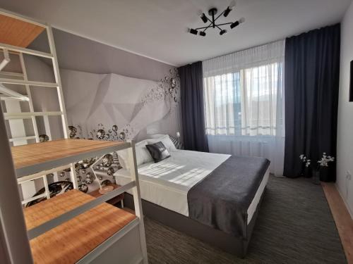 a small bedroom with a bed and a window at Cliché Luxury Apartment in Braşov