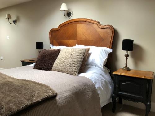 a bedroom with a large bed with a wooden headboard at Little Doric in Shepton Mallet