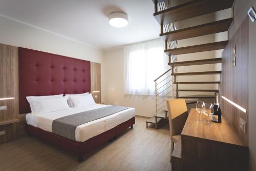 Schlafzimmer mit einem großen Bett mit einem roten Kopfteil in der Unterkunft Hotel Residence Vallecorsa in Vada