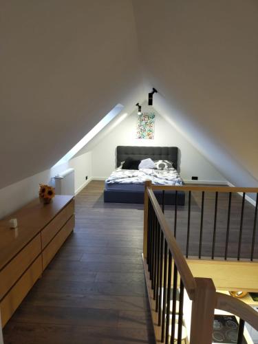 a attic bedroom with a bed and a staircase at VIP Apartament Sosnówka in Sosnówka